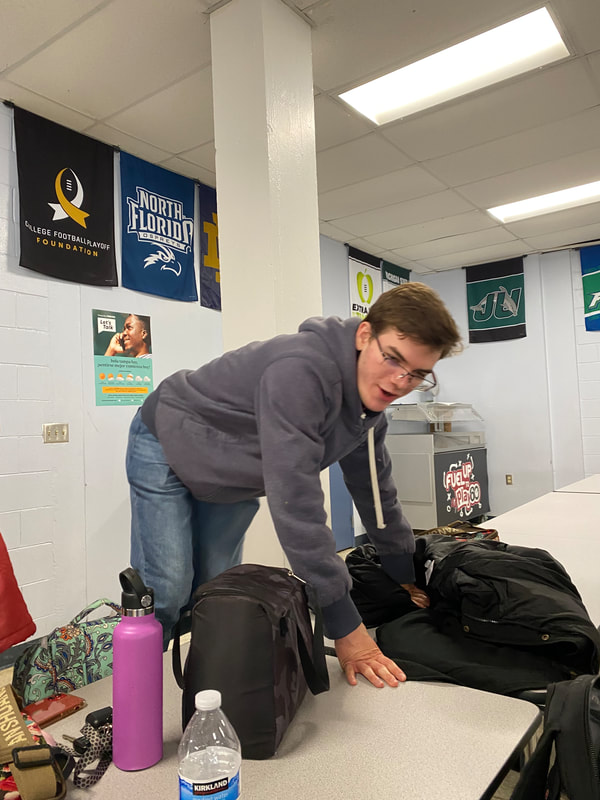 A student appears to be climbing a cafeteria table. 